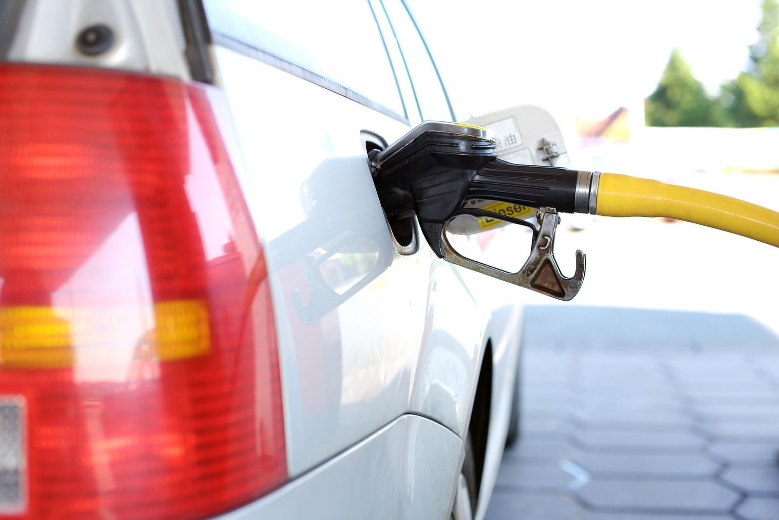 A close up of a vehicle refuelling at a fuel station with a blurred background.