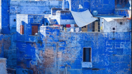 A detailed, abstract photo of the blue-washed walls of houses in the city of Chefchaouen, Morocco.