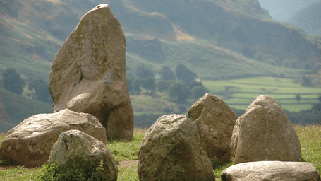 Ancient standing stones of Castlerigg Stone Circle surrounded by scenic hills and countryside views.