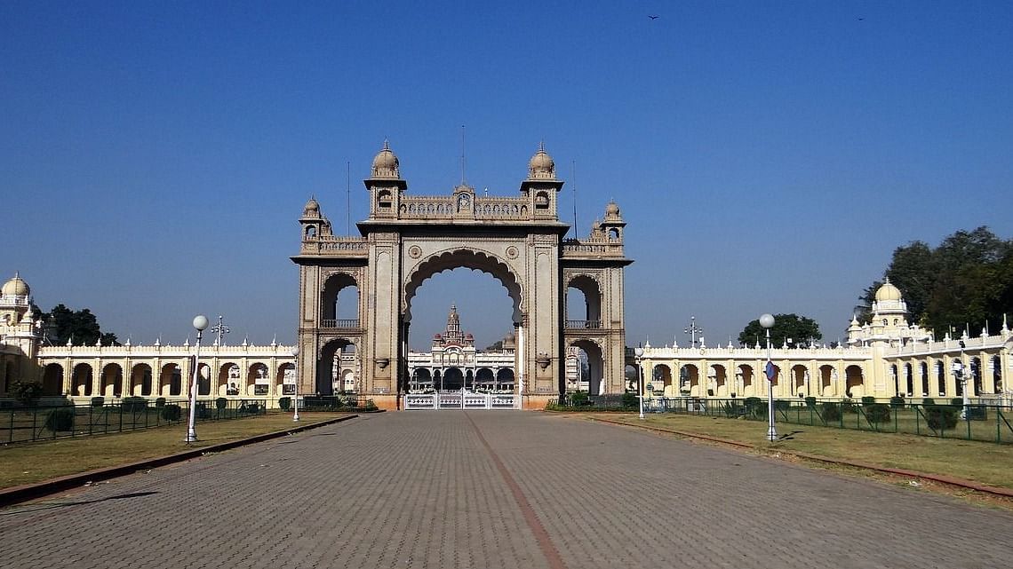 Majestic entrance gate with white arches and a pathway leading through.
