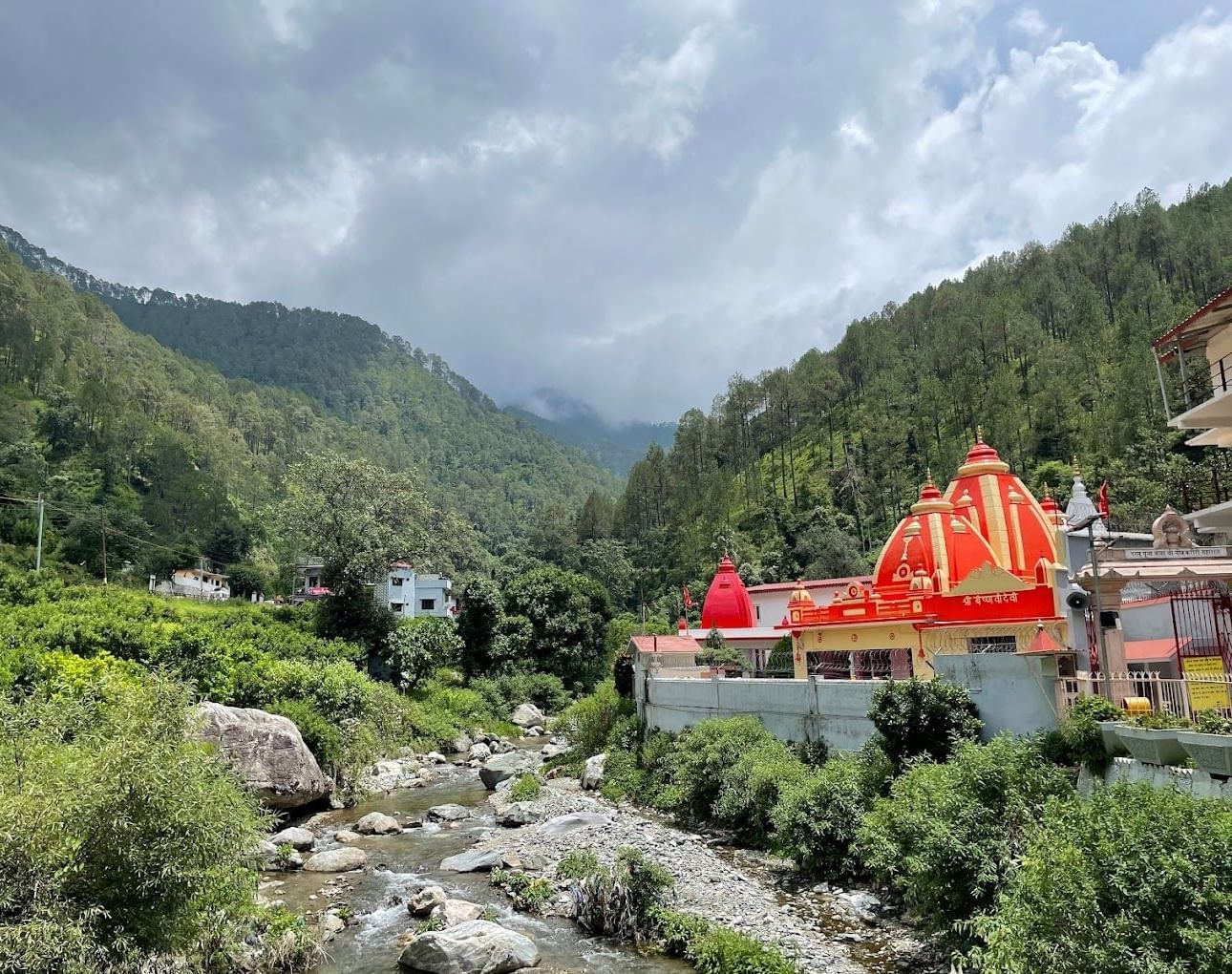 Temple with a bright dome set against hills.