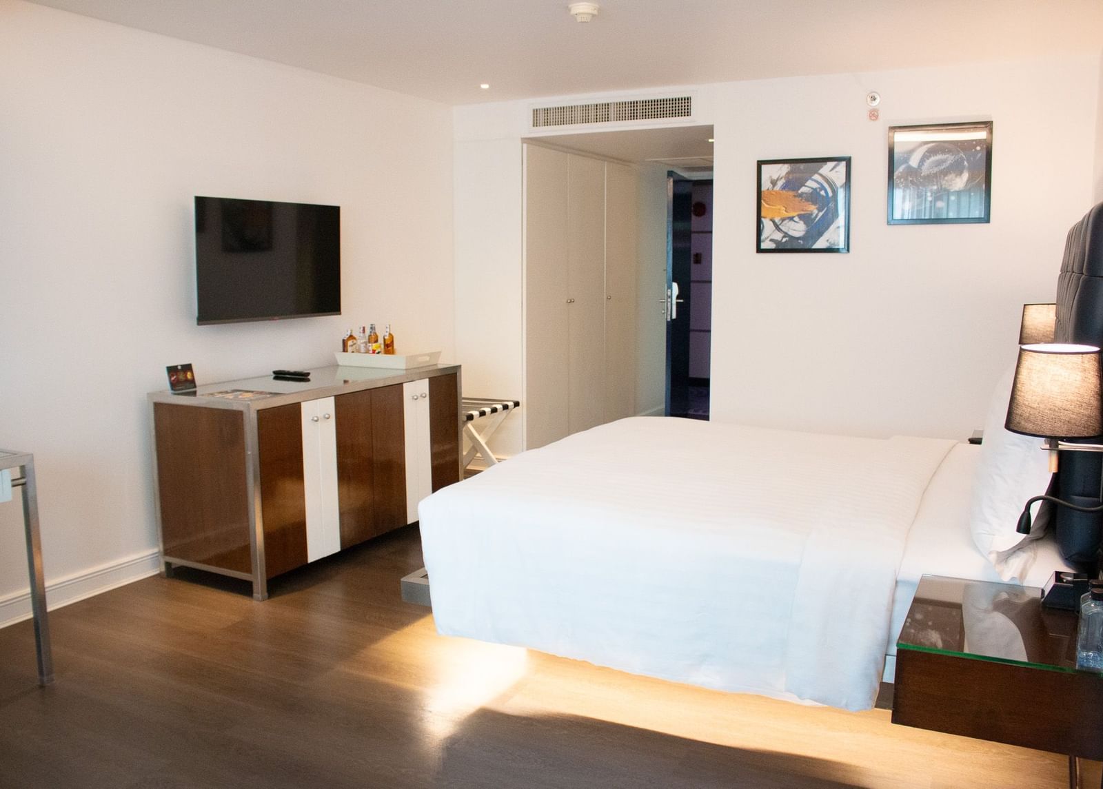 Guest room at Night Hotel Bangkok with king bed, TV, and bright natural lighting.