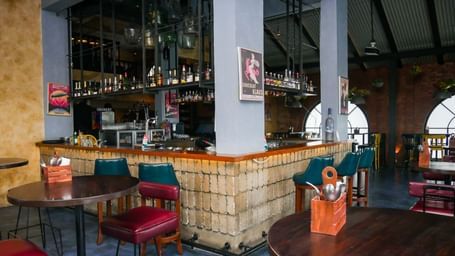A stylish hotel bar with comfortable seating and a wide selection of beverages, inviting guests at Shilton Dee Cee.