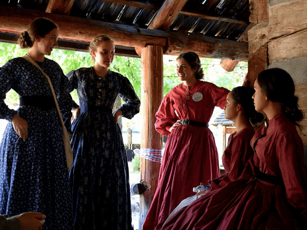 Women talking to each other in a wooden cabin - Narrow Gauge Inn - A Serenite Hotel Near Fish Camp.