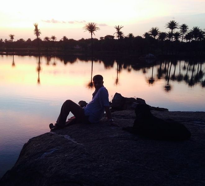 A person enjoying a sunset with his dog at dev shree, deograh