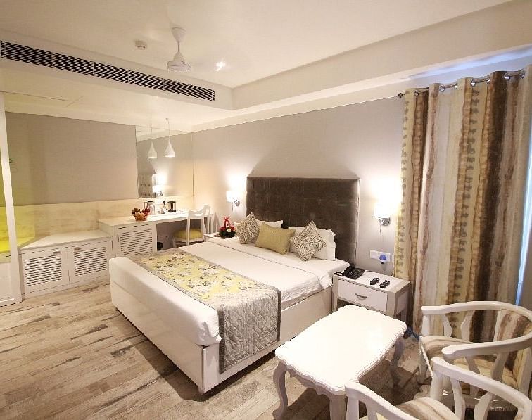 A stylish hotel room with a comfortable bed, elegant furnishings, and soft lighting - Hotel Emerald, Chandigarh