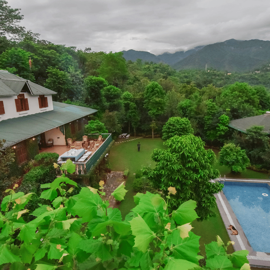 An aerial view of the lush green landscape with a resort nestled amongst the hills.