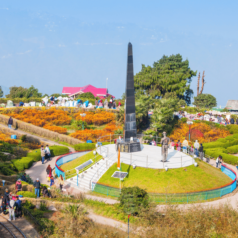 Landscaped gardens and the Batasia Loop war memorial monument near Tiger Hill in Darjeeling surrounded by colourful flower beds.