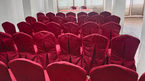 Interior of a hall with neatly arranged chairs and a table in the center