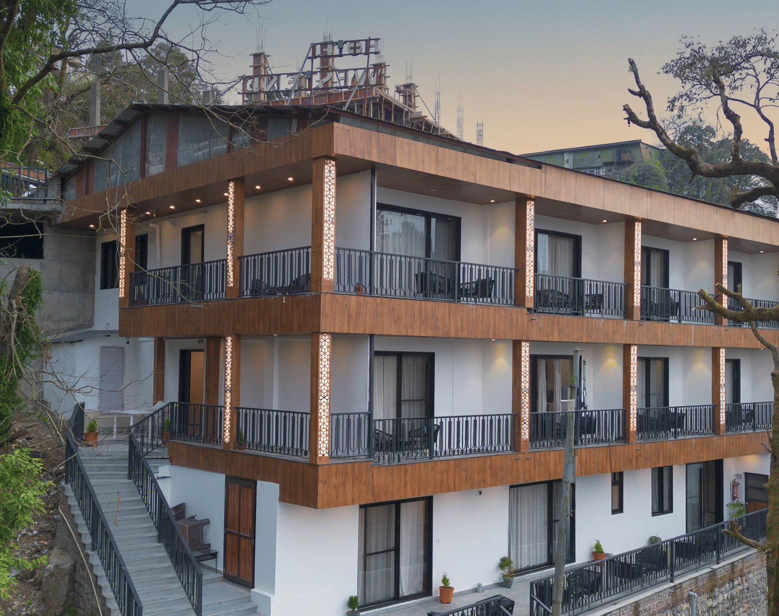 A beautiful facade of the Perfectstayz Premium Westend Mall Road, Mussoorie, featuring a 3-storey building with balconies.