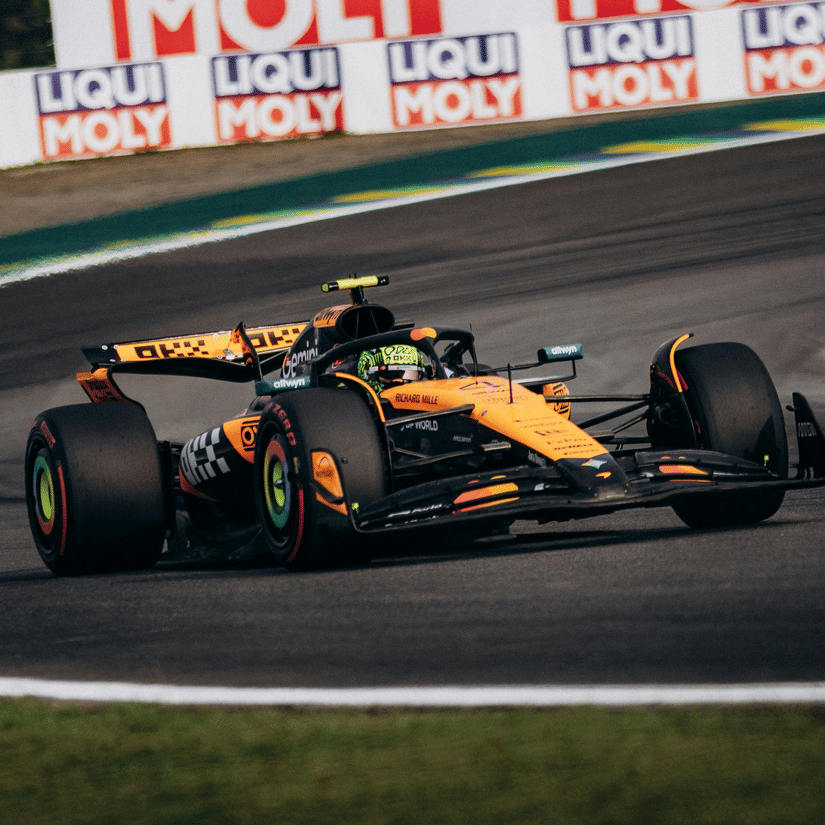 A view of the Mclaren F1 car moving along on the Qatar Grand Prix 2026 with advertising hoarding in the background.