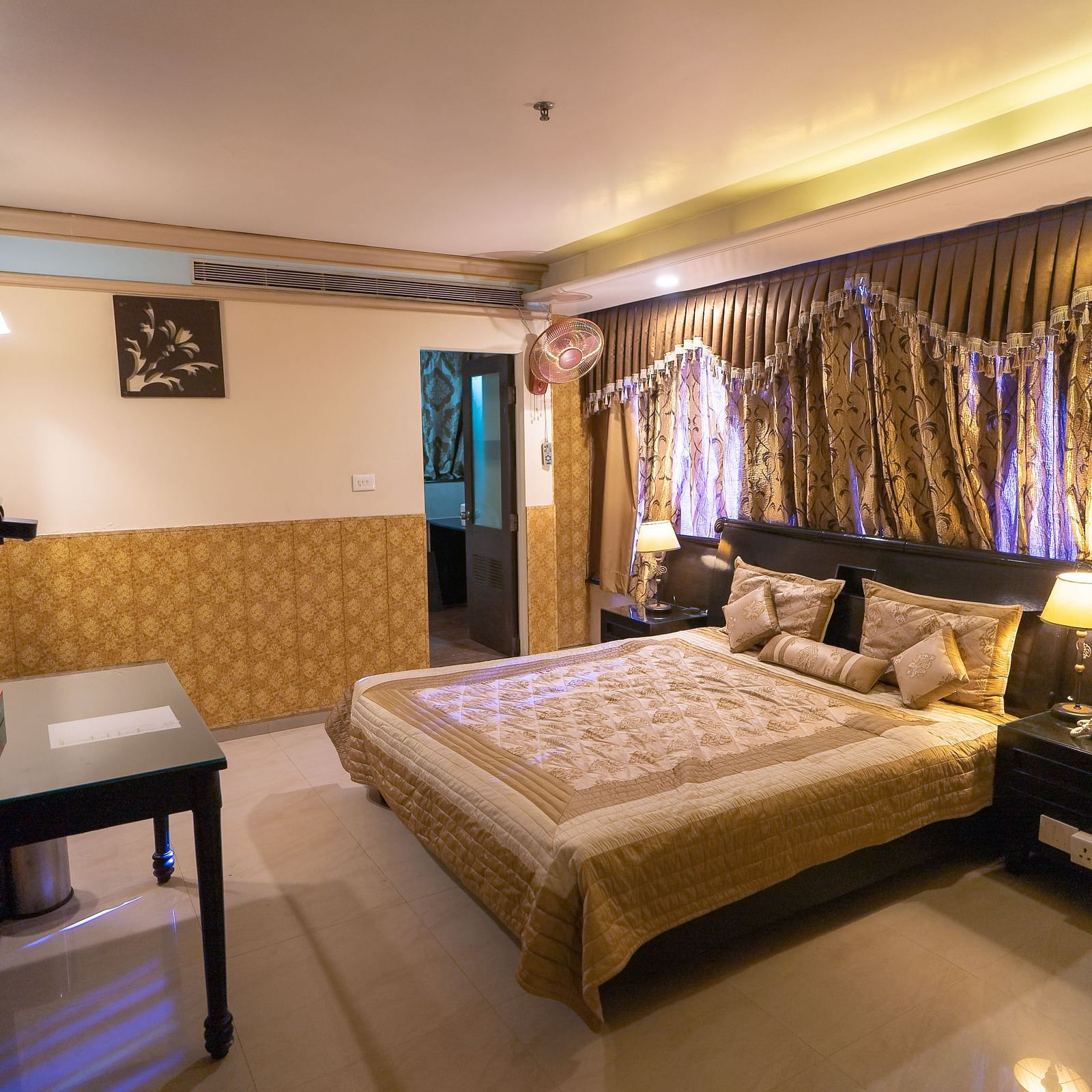 Queen Room featuring a bed, a desk, and a television. - Hotel Ashok Nagpur