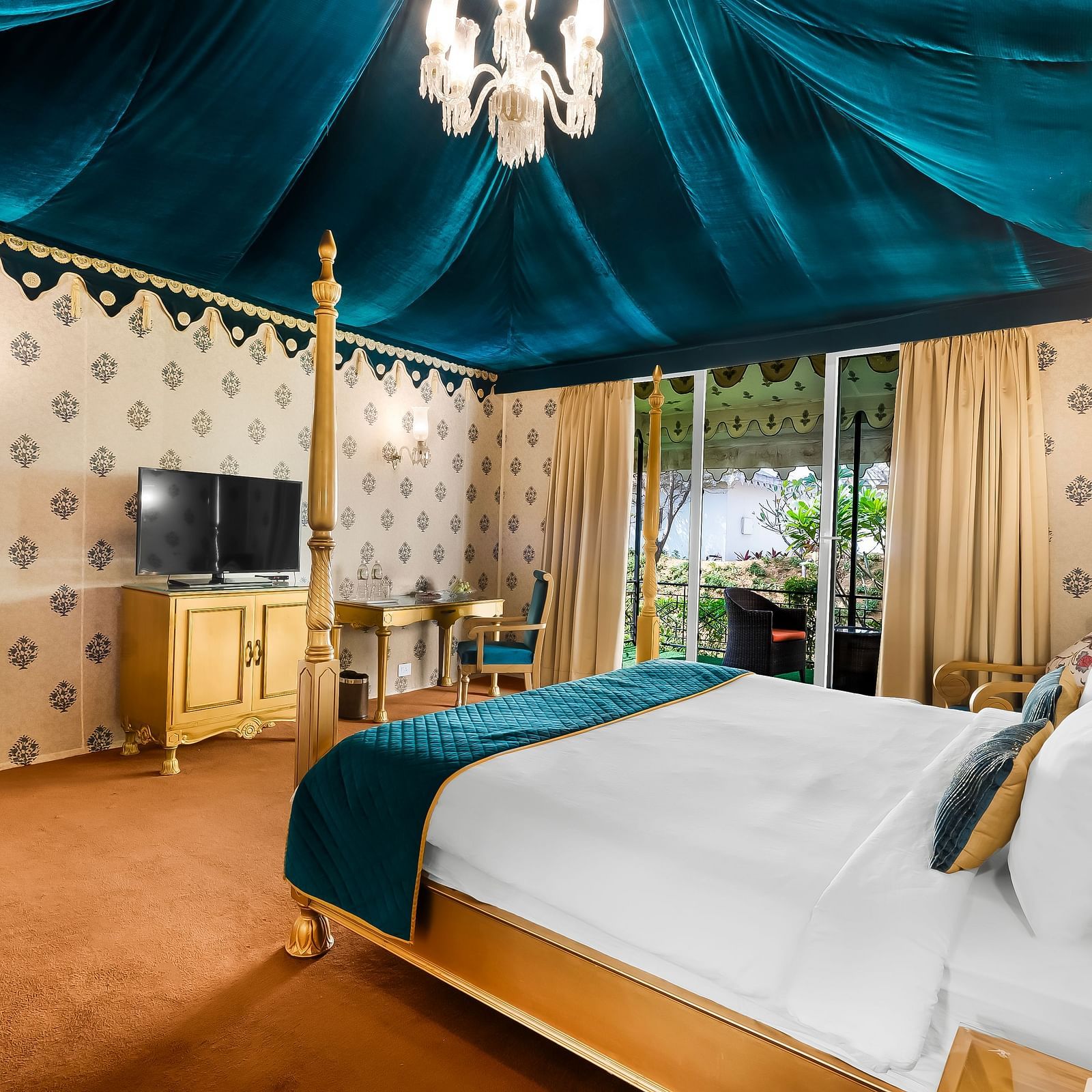An overview of a tent with a double bed and a tv in front of it - Rajasthali Resort & Spa, Jaipur.