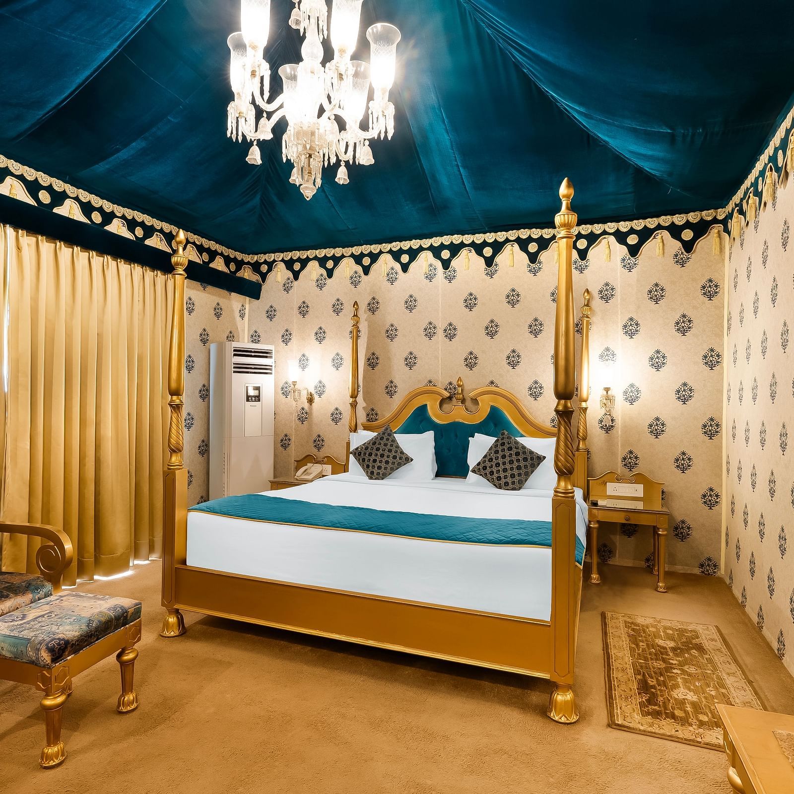 An overview of a tent with a double bed, a chair and a table seen inside it - Rajasthali Resort & Spa, Jaipur.
