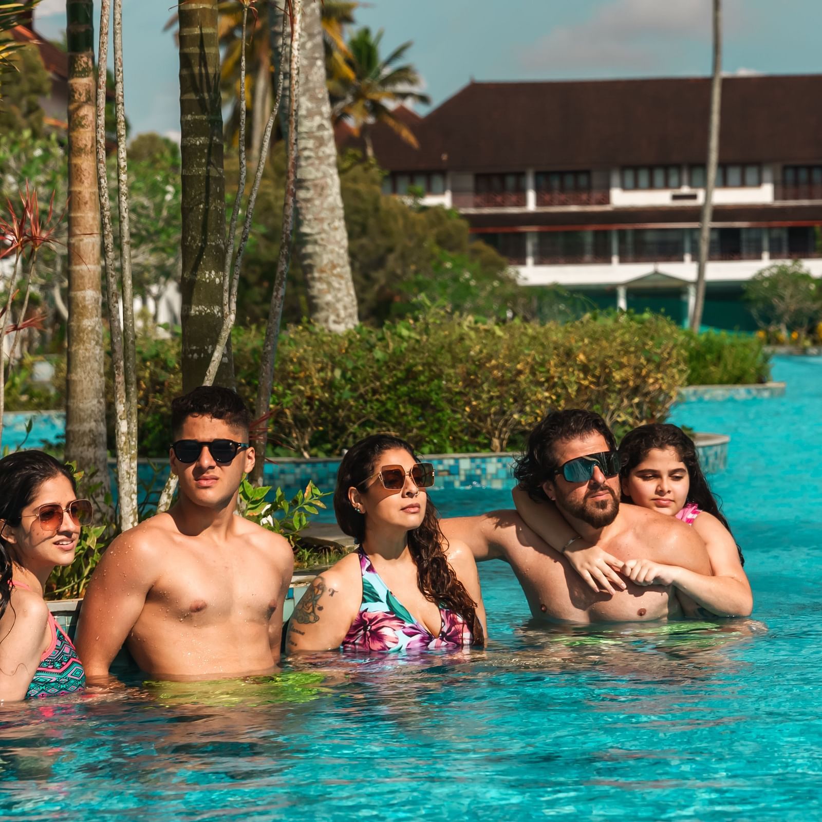 an image of a group of people in pool posing for a picture - Rhythm Kumarakom