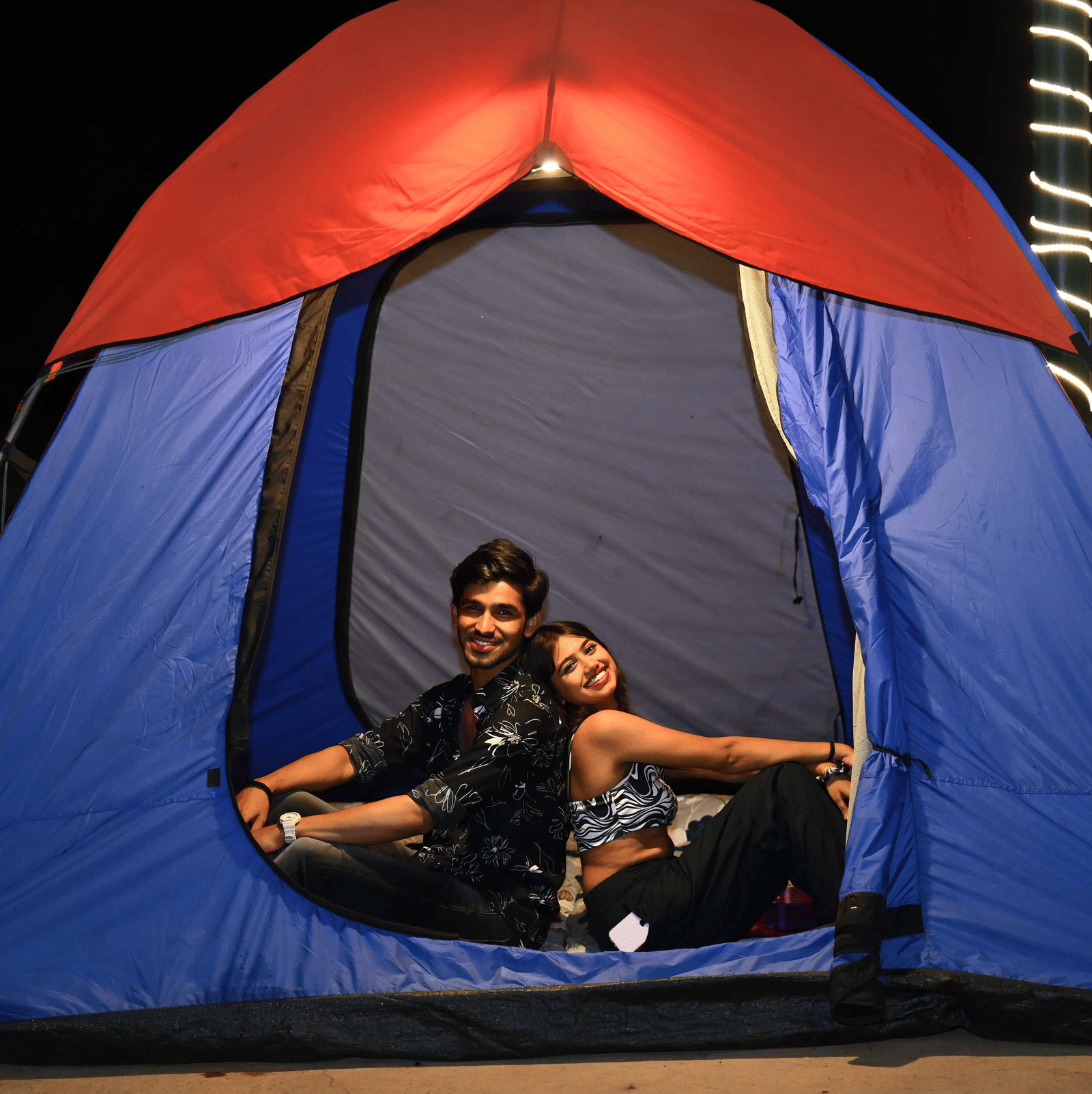 A couple posing for a picture at the entrance of a tent inside Diamond Parks, Pune.