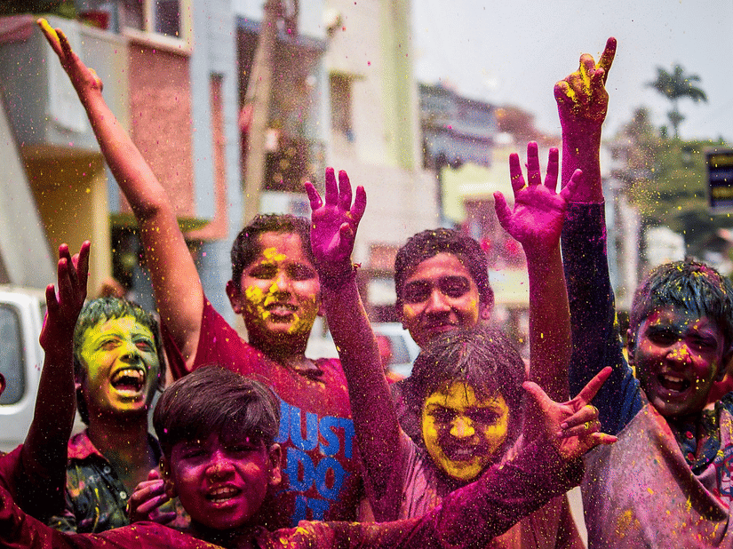 Guests joyfully celebrate Holi, covered in vibrant colors, creating festive memories at Ramada Plaza by Wyndham Palm Grove.