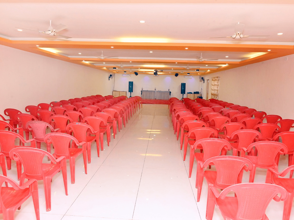 An image of the seating arrangement at the banquet hall  with a table and chairs placed on a podium at Nisarga Lake Resort
