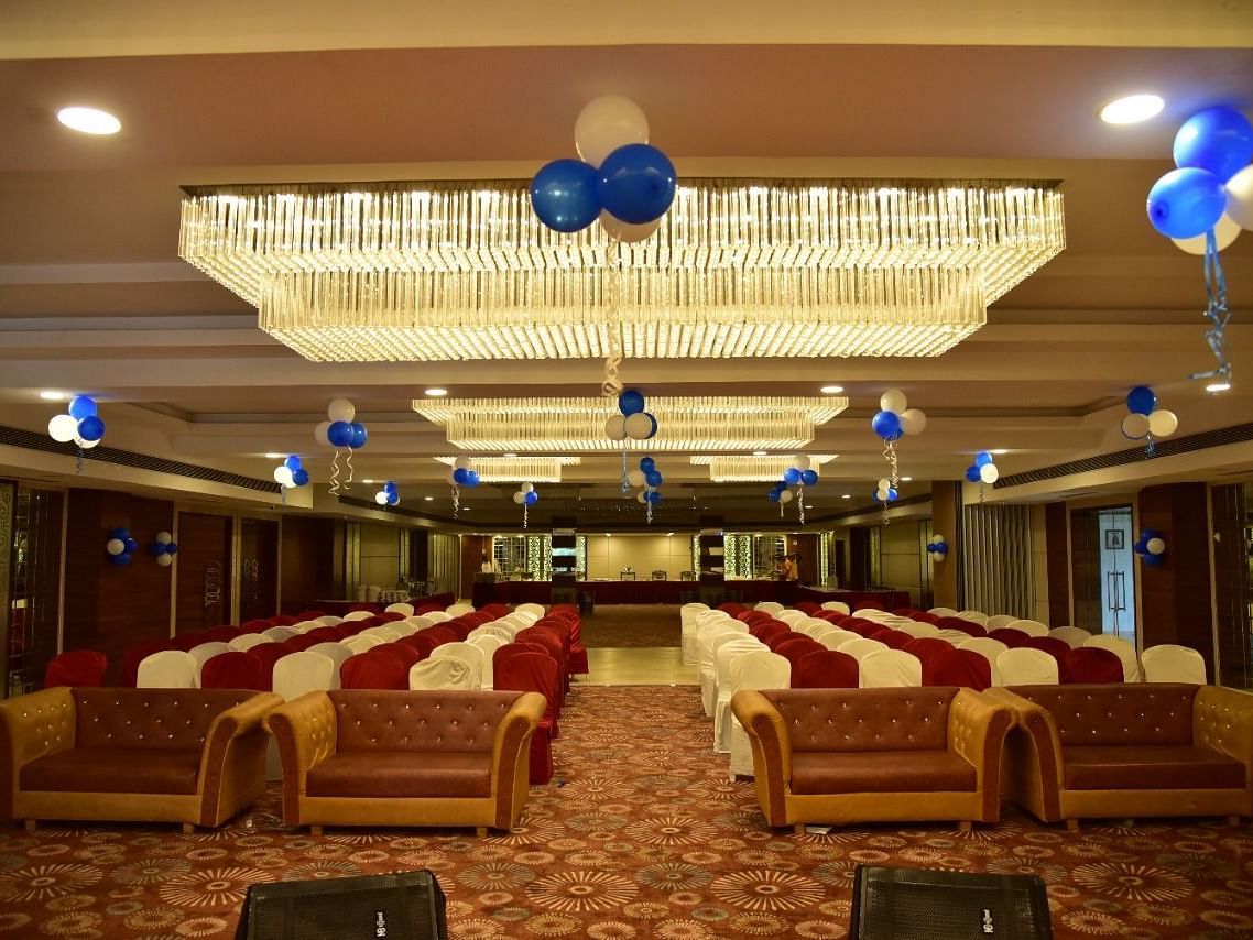 A decorated banquet hall at Rang Lords Inn, with arranged seating and festive balloons, prepared for a celebration or event
