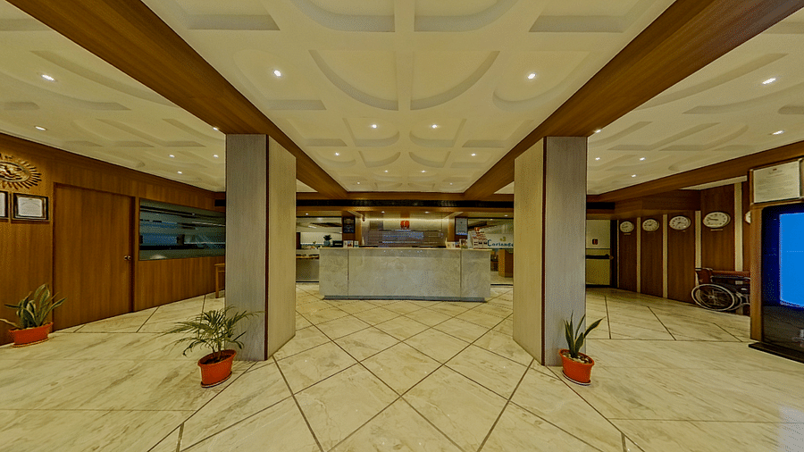 Elegant hotel lobby with marble floors, ornate ceiling and wooden panels at Lords Eco Inn Dahej, creating a welcoming entrance for guests.