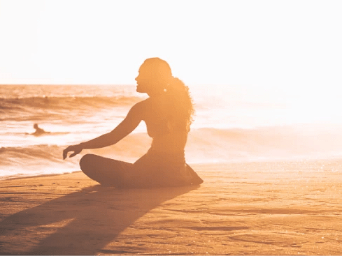 A person meditating on a sandy beach at sunrise - S Hotel Montego Bay, Jamaica