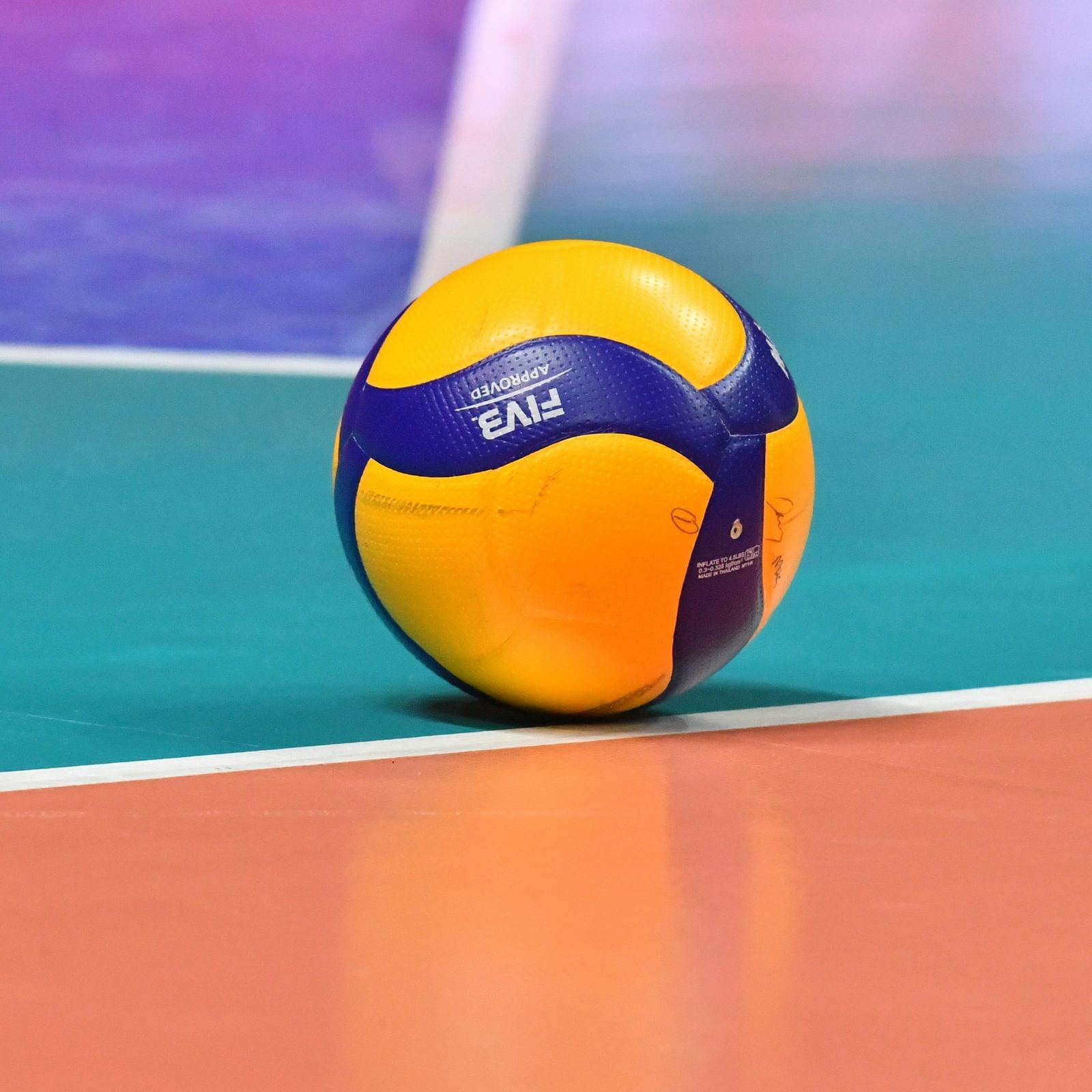 A voleyball placed on a painted court.