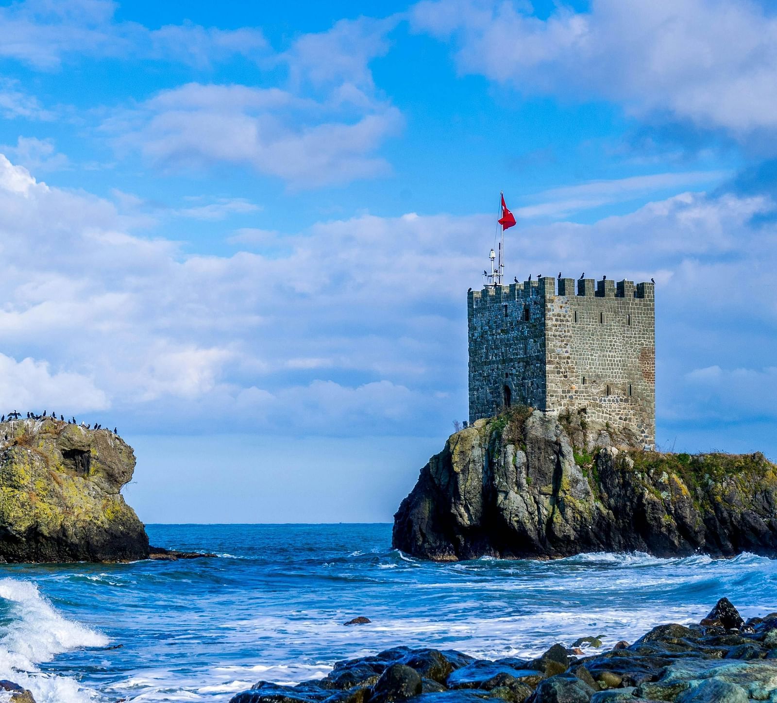 A view of the fort from the shore, with a cloudy sky