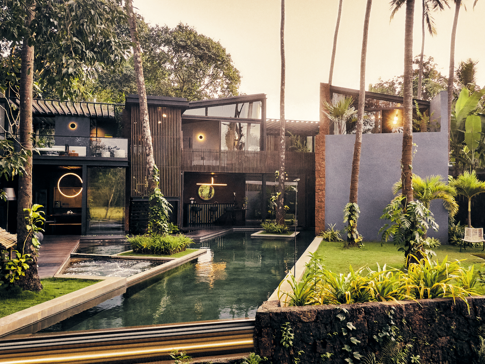 Image of Villa in Palms by V Escapes showing a lush lounging area with plants and pool