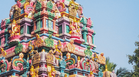 Multi-tiered temple tower adorned with vibrant sculptures and decorative artwork