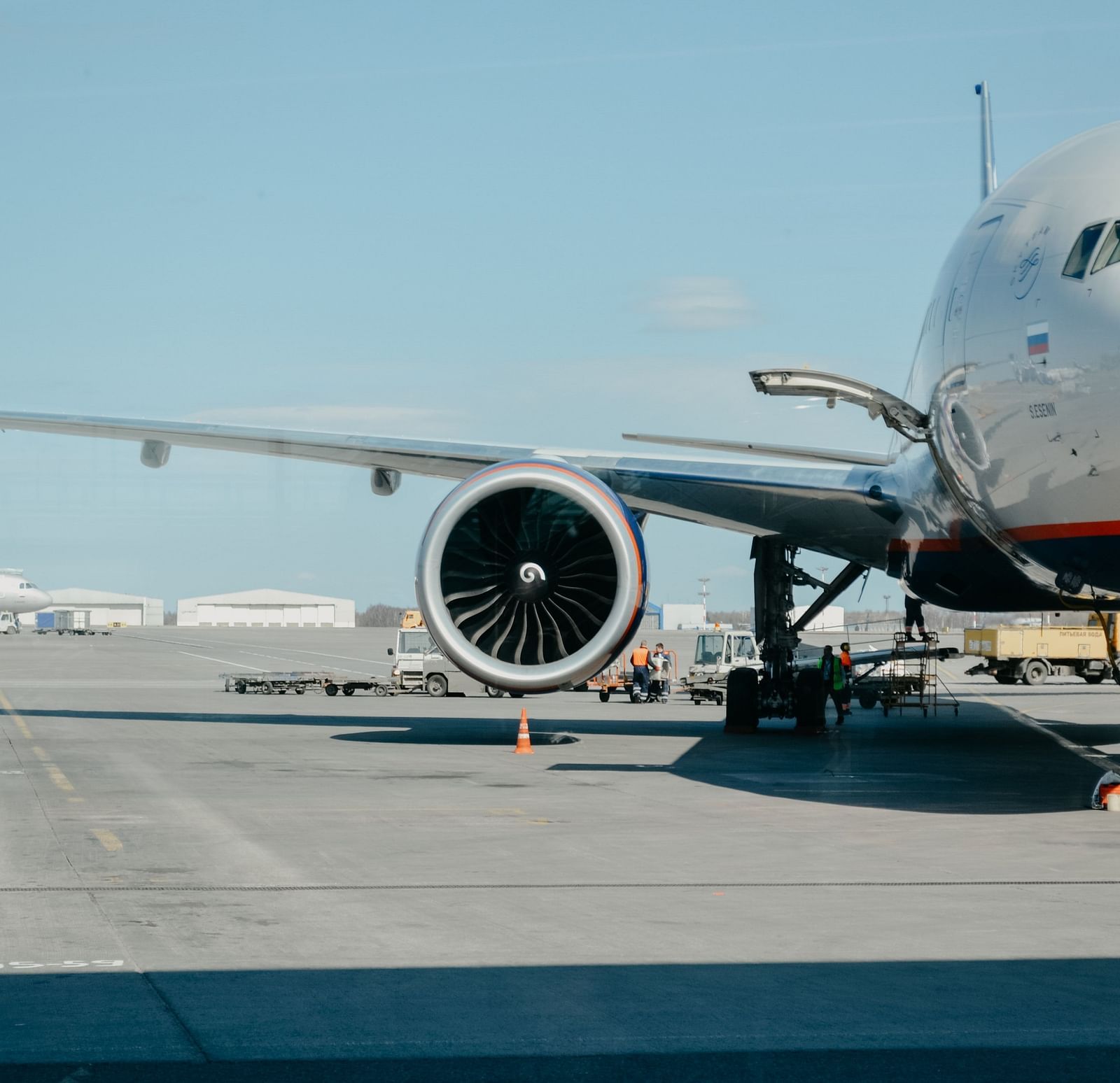 An aeroplane parked in an airport as seen from inside the terminal.