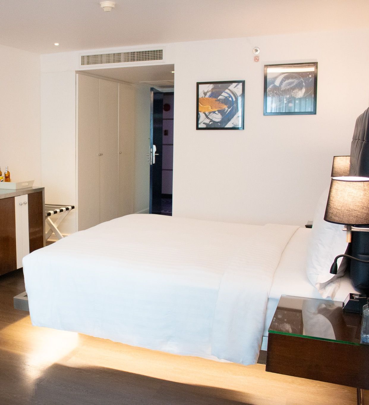 Guest room at Night Hotel Bangkok with king bed, TV, and bright natural lighting.
