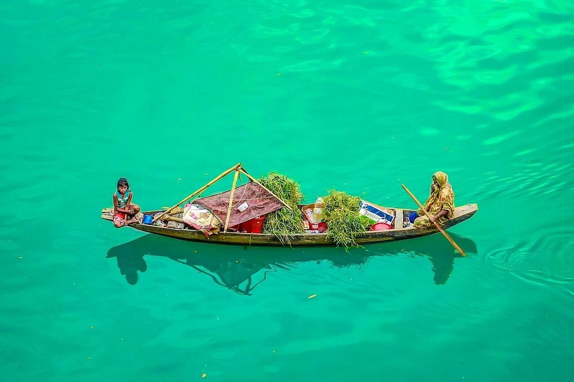 An aerial view of a woman and her child on a boat having various vegetables to be sold.