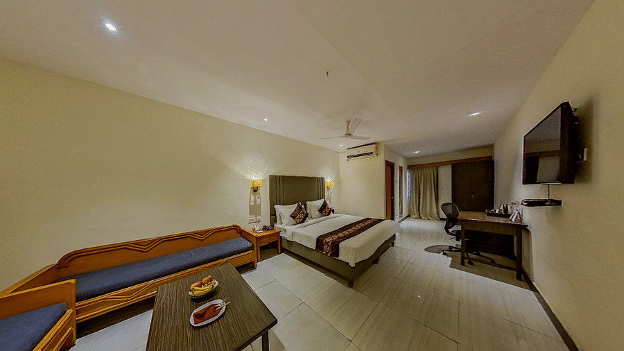 Deluxe hotel suite at Lords Eco Inn Dahej with comfortable seating area, work desk, modern interiors, and panoramic room layout