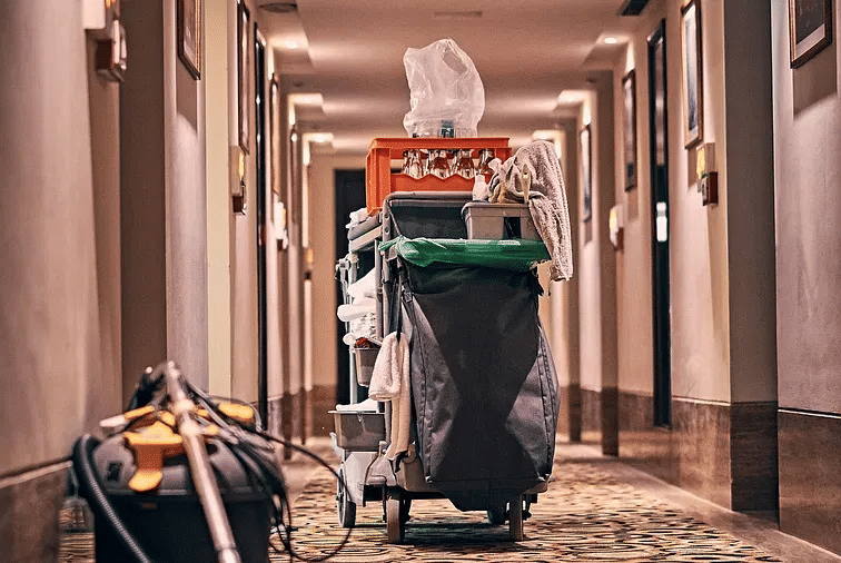 A housekeeping trolley with cleaning supplies in a hotel corridor