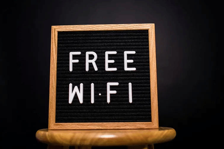 A chalkboard sign on a wooden stand displaying Free Wi-Fi