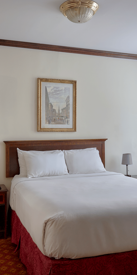 Room at Night Hotel Broadway showing a bed, framed wall art, and window near the corner.