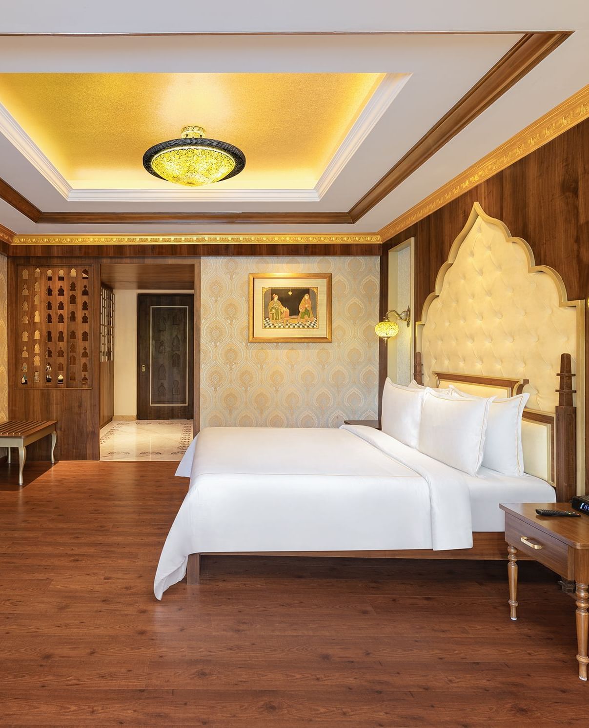 A hotel room in Mahabalipuram with rich wooden flooring, a large bed, and comfortable seating arrangement – Kaldan Samudra, one of the top beach resorts in ECR