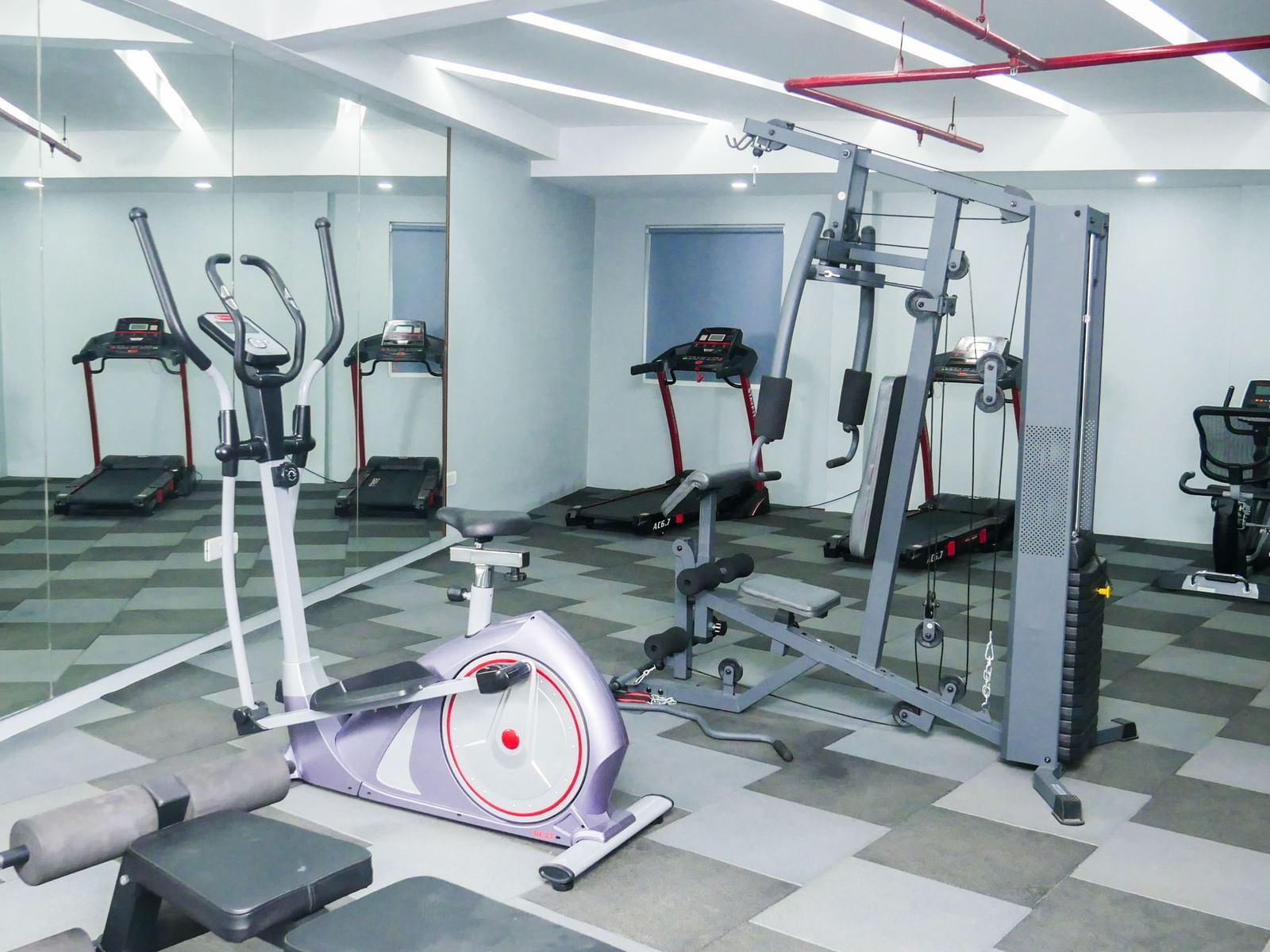 A well equipped hotel gym with various exercise machines and a clean floor, ready for a workout at Shilton Dee Cee.