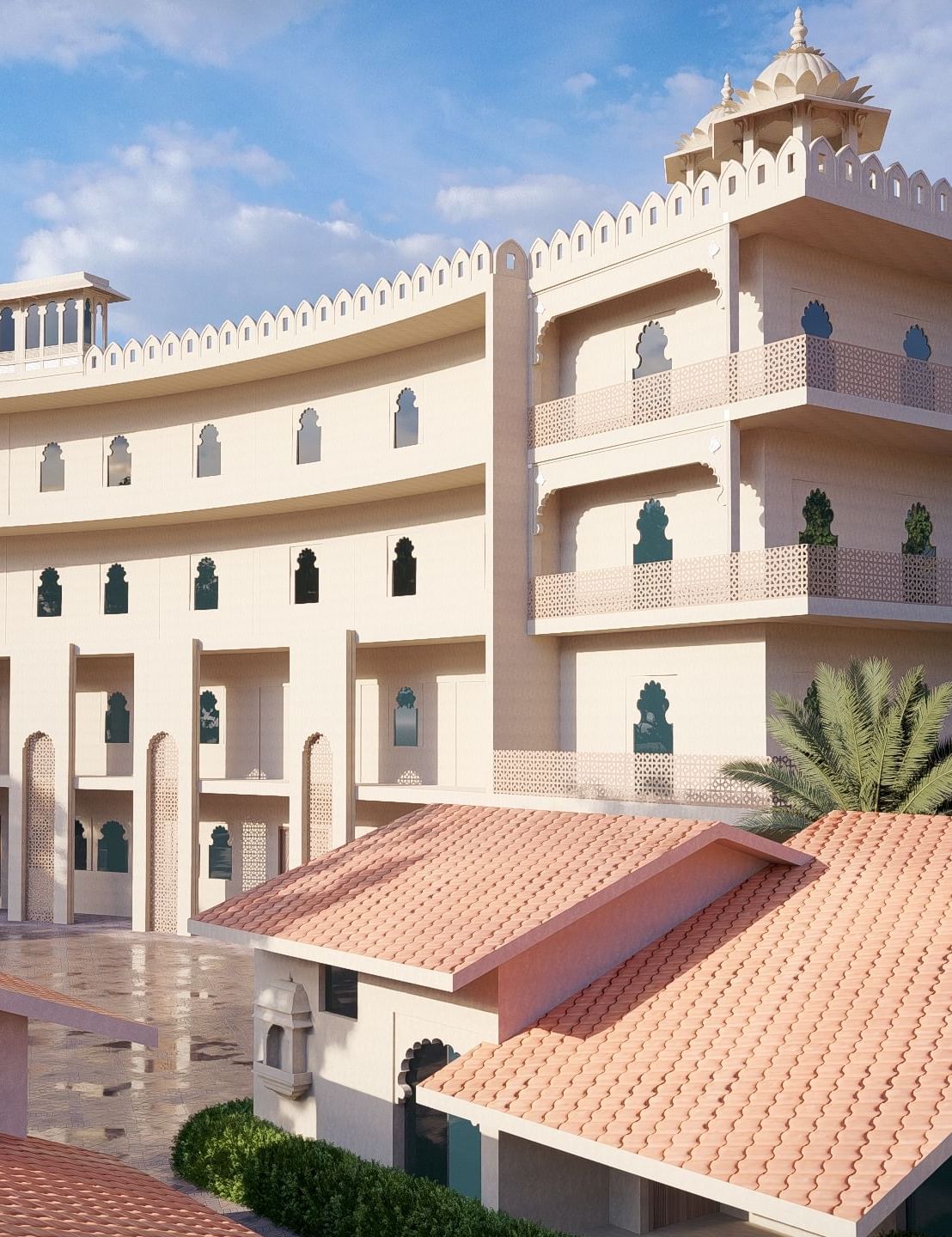 Curved exterior of the large, multi-storey Bamboo Saa Sunrise Wedding & Wellness Resort, Jaipur, with a terracotta-tiled roof in the foreground.