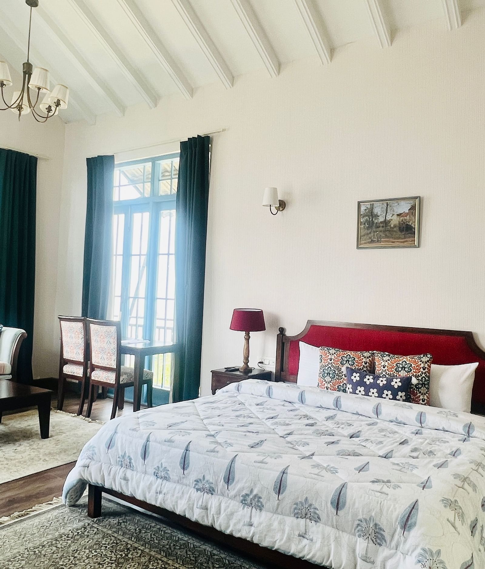 Bright hotel room with wooden floor, blue drapes, and comfortable bed | Faraway Cottages, Auli