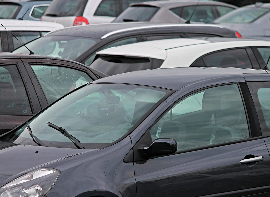 Rows of cars parked in an open space.