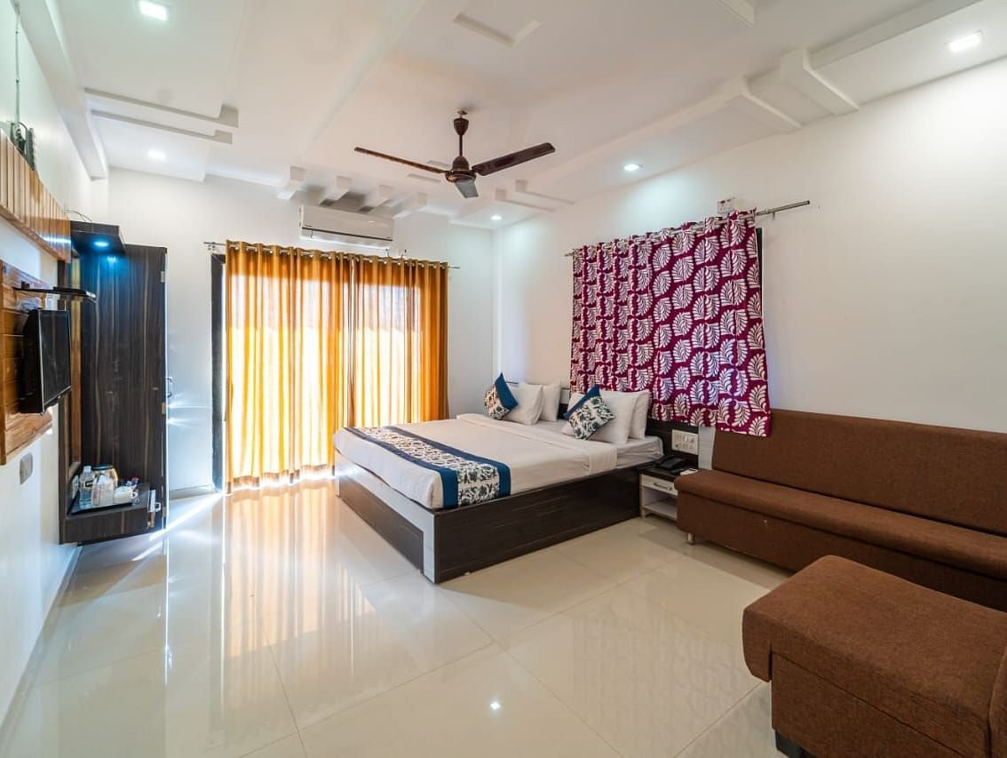 Deluxe Valley View Room featuring a king size bed, a sofa, and a television. 