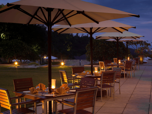 outdoor seating at Odyssey Restaurant at The Serai Chikmagalur as seen during twilight.