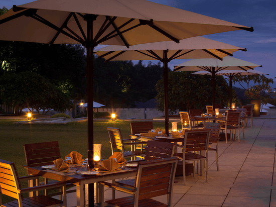 Outdoor seating at Odyssey Restaurant at The Serai Chikmagalur as seen during twilight