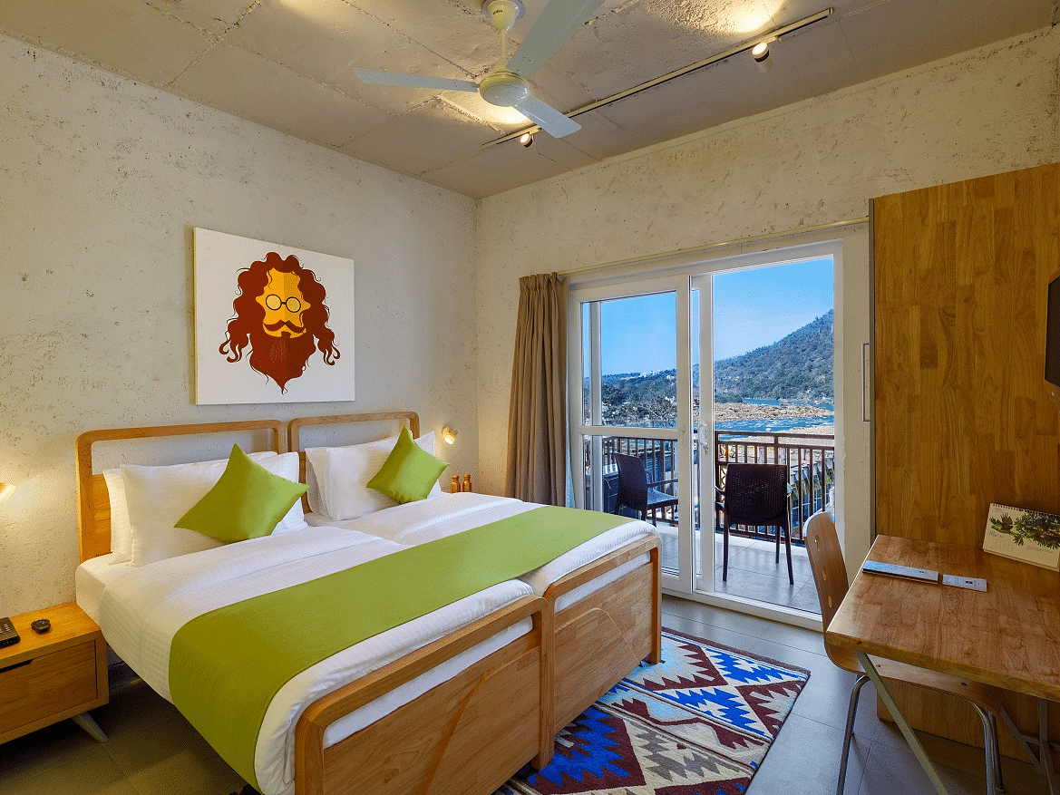 A bedroom with mountain view window at Bedzzz, Rishikesh 
