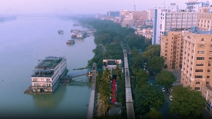 Aerial view of Polo Floatel beside a railway track and river, featuring a red carpet and buildings in the background.