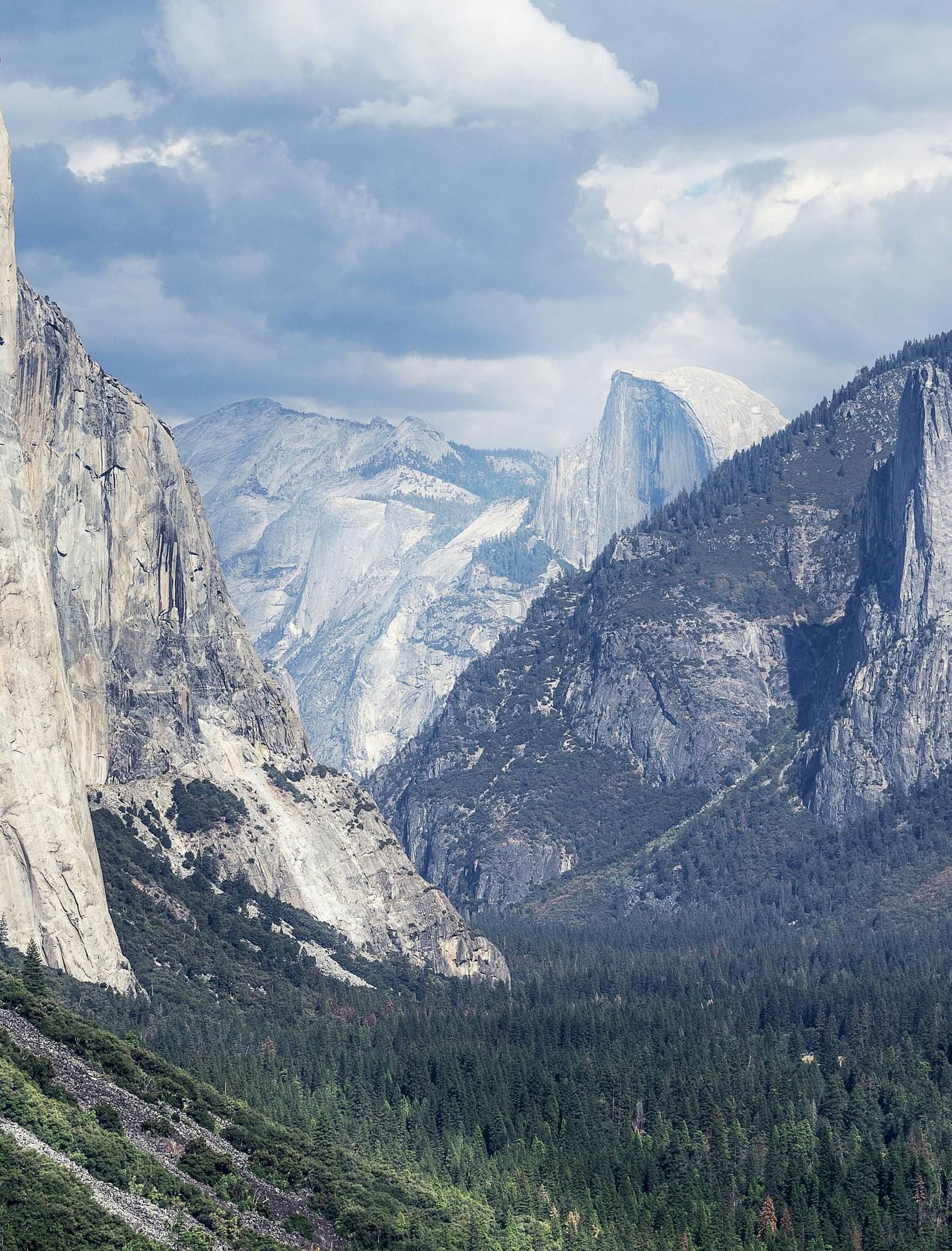 Image of a valley at Yosemite National Park with snow-capped mountains in view.