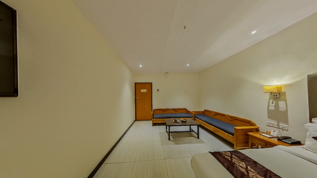 Spacious family room at Lords Eco Inn Dahej with L-shaped seating, coffee table, additional beds, and premium hospitality features