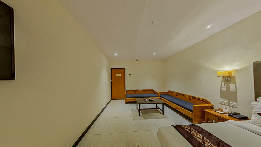 Spacious family room at Lords Eco Inn Dahej with L-shaped seating, coffee table, additional beds, and premium hospitality features