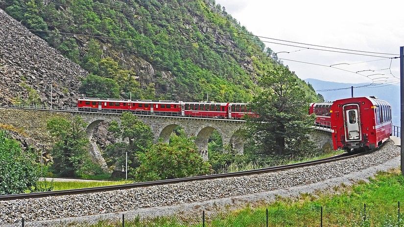 Colourful train surrounding beautiful mountains
